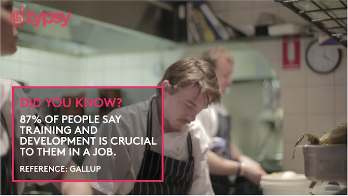 A young man works in a restaurant kitchen with text in red font superimposed on top of the image.